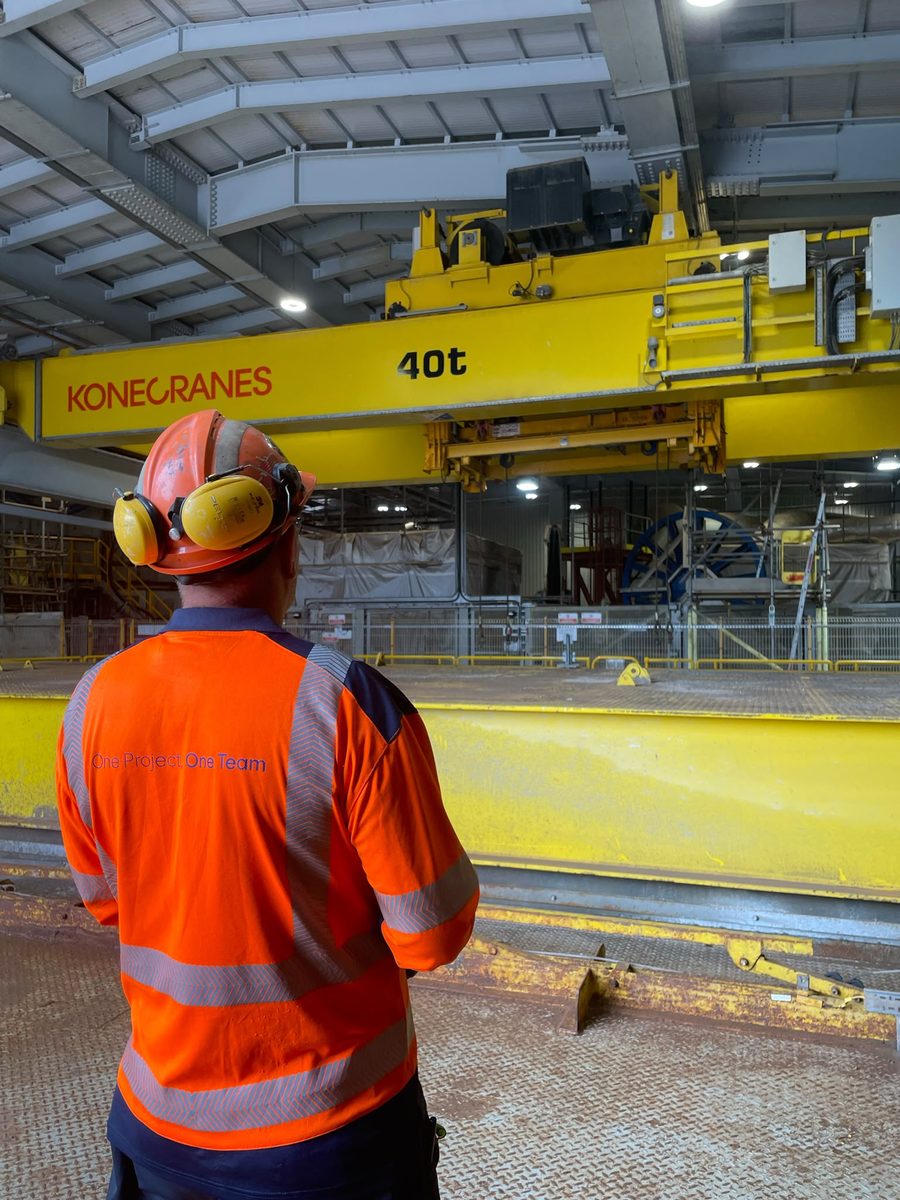 An instructor observing a 40 tonne Konecranes overhead gantry crane in a mining plant during a training assessment